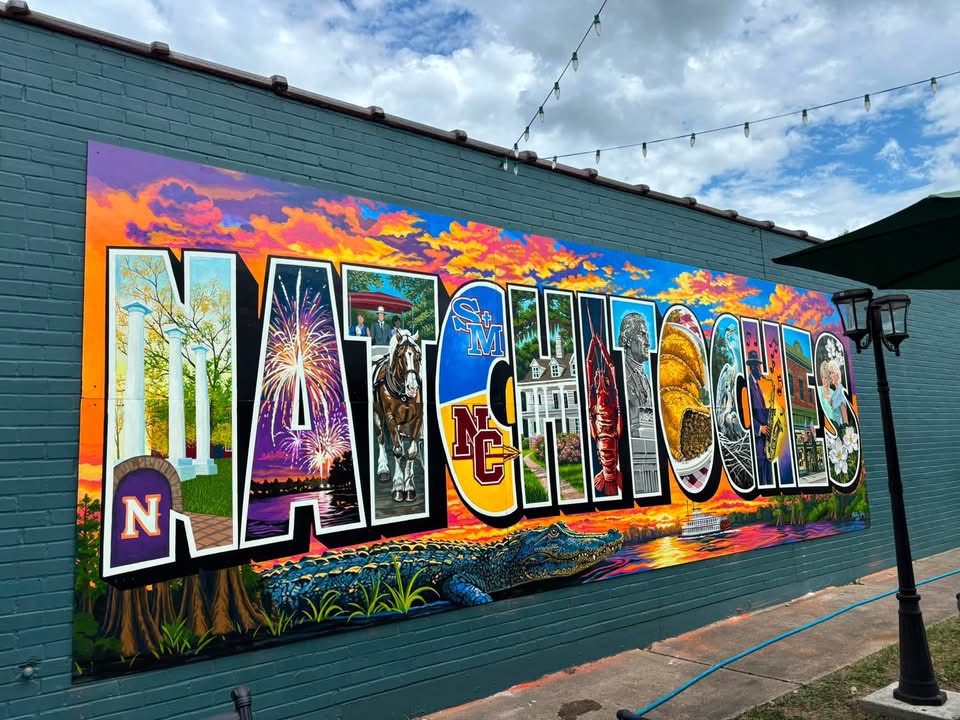 Colorful Natchitoches mural banner featuring local landmarks, culture, music, food, and the Cane River